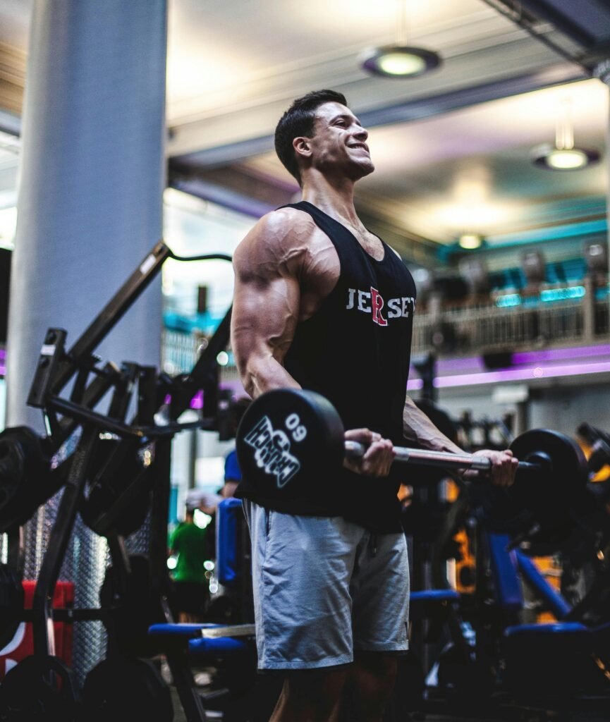 Focused man lifting weights at the gym, showcasing muscular physique and strength
